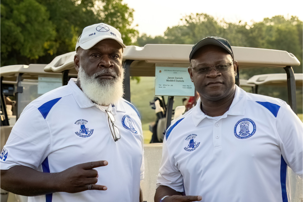 Two Phi Beta Sigma Fraternity members at a community golf event, representing brotherhood, leadership, service, and community engagement.
